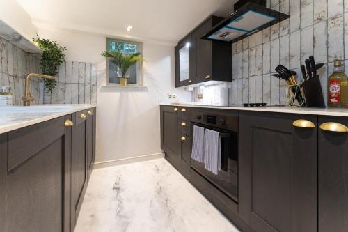 a kitchen with dark brown cabinets and a sink at Host & Stay - Luxe on Margaret Street in Brighton & Hove