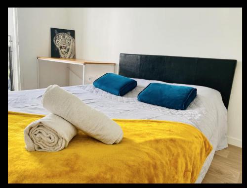 - un lit avec 2 oreillers et des serviettes dans l'établissement Cosy Appart, à Stains