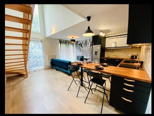 une cuisine avec une table, des chaises et un canapé bleu dans l'établissement Cosy Appart, à Stains