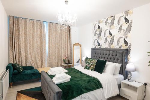 a bedroom with a bed and a green couch at Cozy Haven Flat in Milton Keynes