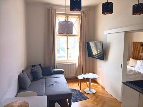 salon z niebieską kanapą i oknem w obiekcie Harmony Residence One WITH JACUZZI w Pradze
