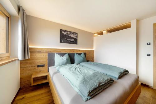 a bedroom with a large bed with blue sheets at Oberhaushof in Santa Valburga St. Walburg