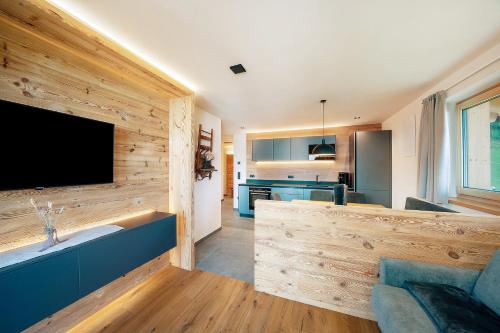 a kitchen and living room with a large flat screen tv at Oberhaushof in Santa Valburga St. Walburg