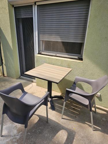 a picnic table and two chairs in front of a window at Apartmani Royal Residence in Golubac