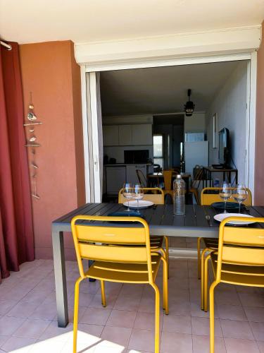 - une table et des chaises avec des verres à vin dans l'établissement SèteÔSoleil, à Sète