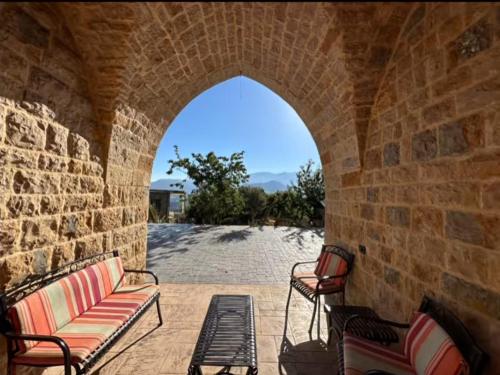 Un arco con dos bancos en una pared de ladrillos. en Bayt Al Habib, 