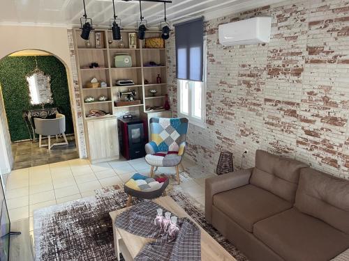 a living room with a couch and a brick wall at Villa De La Vita Alykes in Katastárion
