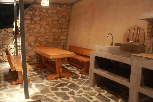 a kitchen with a sink and a table and a bench at Villa De La Vita Alykes in Katastárion