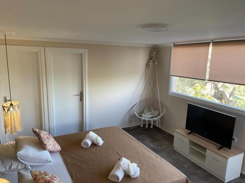 a bedroom with a bed and a flat screen tv at Villa De La Vita Alykes in Katastárion