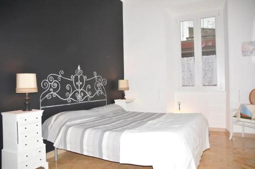 una camera con un letto bianco e una parete nera di Cosy Apartment - 5 Minutes Walk from Colosseum a Roma
