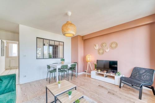 - un salon avec une table, des chaises et une télévision dans l'établissement Le Grand Voyageur - 3 chambres - Parking privé - Métro, à Vénissieux