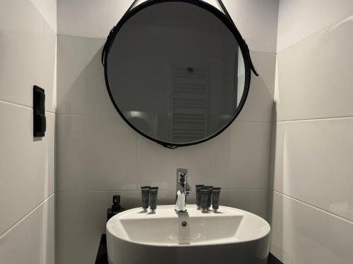 a bathroom with a white sink and a mirror at Apartamenty Florina Q4Apartments in Łeba