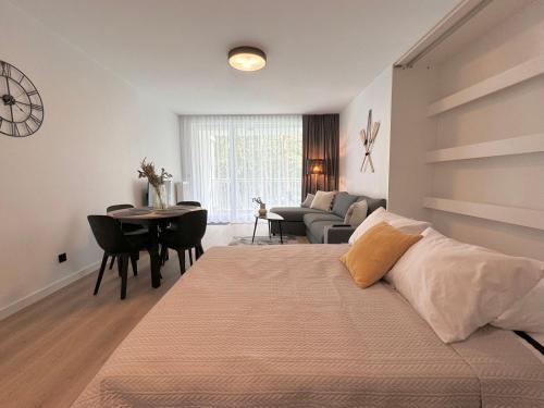 a bedroom with a bed and a living room at Apartamenty Florina Q4Apartments in Łeba
