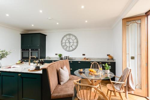 a kitchen with green cabinets and a glass table at Killerby Old Hall with Hot Tub and Swimming Pool in Scarborough
