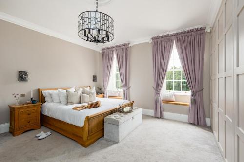 a bedroom with a large bed and a chandelier at Killerby Old Hall with Hot Tub and Swimming Pool in Scarborough