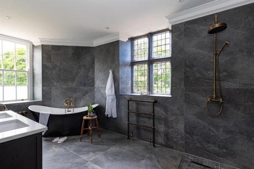 a bathroom with a bath tub and a sink at Killerby Old Hall with Hot Tub and Swimming Pool in Scarborough