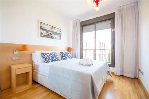 a bedroom with a white bed and a large window at campezo in Madrid