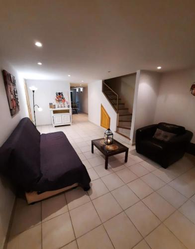 un salon avec un canapé et une table dans l'établissement T2 PATIO avec jacuzzi et PISCINE 100m2 au pied du Luberon, à Cheval-Blanc