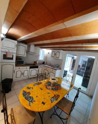 une cuisine avec une table jaune et des chaises dans l'établissement T2 PATIO avec jacuzzi et PISCINE 100m2 au pied du Luberon, à Cheval-Blanc