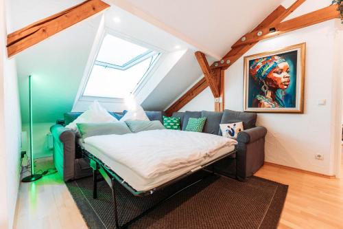 a bedroom with a bed in a room with a window at Spacious Penthouse with AC and Free Parking Steps Away From the Central Station in Koblenz