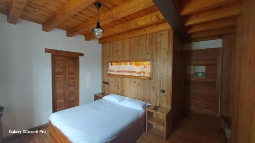 a bedroom with a bed and a wooden wall at Ristorante Hotel Falchetto in Brunate