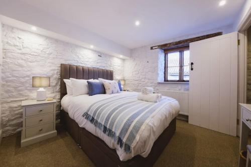 a bedroom with a large bed and a stone wall at The Stable- Hopewell in Bristol