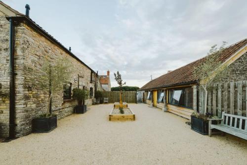 a courtyard of an old building with two benches at The Stable- Hopewell in Bristol