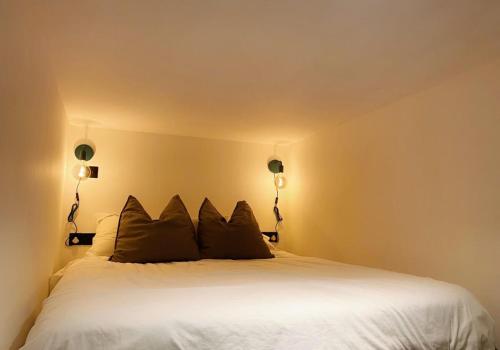 een slaapkamer met een wit bed met 2 kussens bij Modern and Bright Three Bed Apartment in Bristol