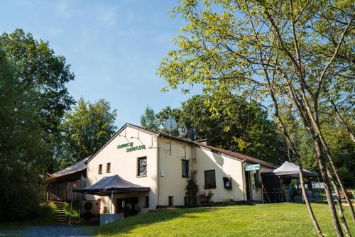 a white building with trees in front of it at Camping De Chênefleur in Tintigny