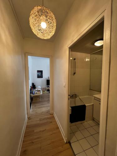 La salle de bains est pourvue d'une baignoire et d'un lustre. dans l'établissement Charmant studio d'artistes - Paris - Parc des princes - Roland Garros - Trocadero, à Boulogne-Billancourt