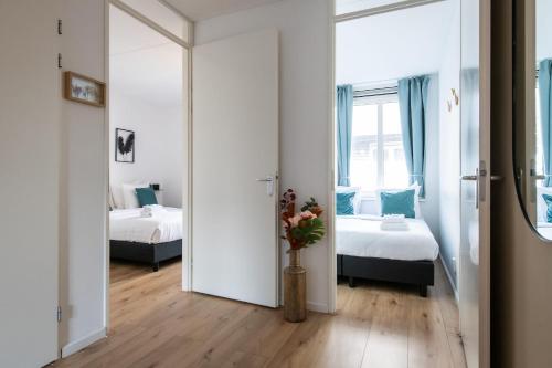 a room with two beds and a vase with flowers at Aparthotel North Spacious Suite for 6 Guests in Amsterdam