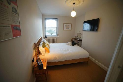 una camera da letto con un letto bianco e una finestra di The Alma Taverns Boutique Suites - Room 3 - Hopewell a Bristol