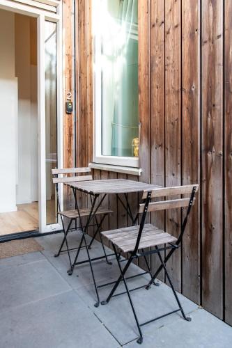 a wooden table and a bench next to a building at Aparthotel North Studio With Patio For 2 in Amsterdam