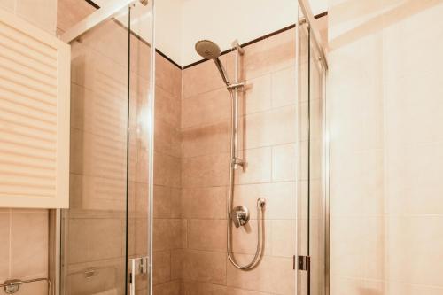 une douche avec une porte vitrée dans une salle de bain dans l'établissement L'Ulivo - Lakeside L&B, à Marinella di Sarzana