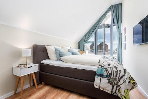a bedroom with a bed with a large window at Portobello in Heiligenhafen