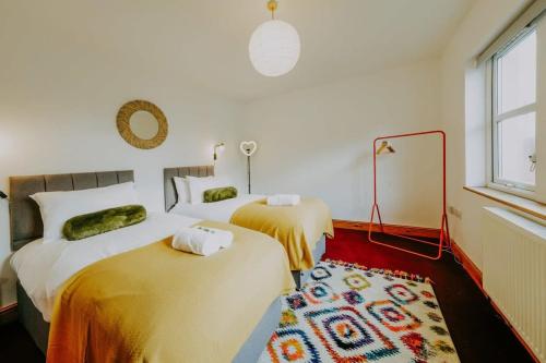 The unicorn's house sleeps 10 people في بريستول: غرفة نوم بسريرين وسجادة