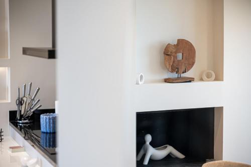 a living room with a fireplace with a person sitting on it at Alhena Pavilion in Bouzéïka