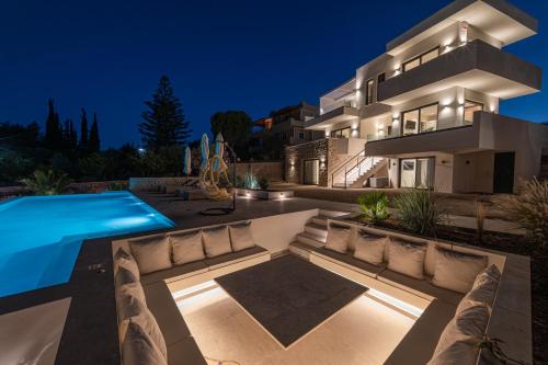 a villa with a swimming pool at night at Alhena Pavilion in Bouzéïka