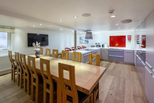 eine Küche und ein Esszimmer mit einem Holztisch und Stühlen in der Unterkunft Host & Stay - Sillwood Seafront in Brighton & Hove
