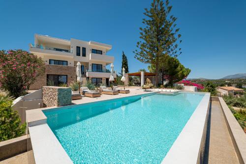 a swimming pool in front of a villa at Alhena Pavilion in Bouzéïka
