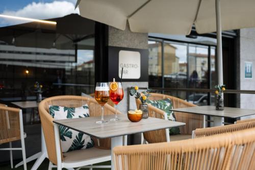 two glasses of wine on a table in a restaurant at Hotel Santiago Plaza Affiliated by Meliá in Santiago de Compostela