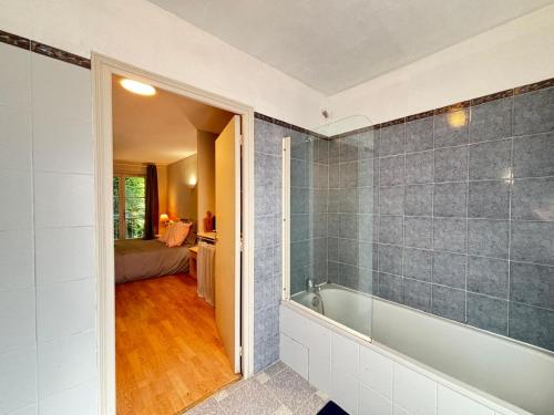 une salle de bain avec baignoire et une chambre dans l'établissement Joli Studio au Golf,Wifi,Parking, à Bellême