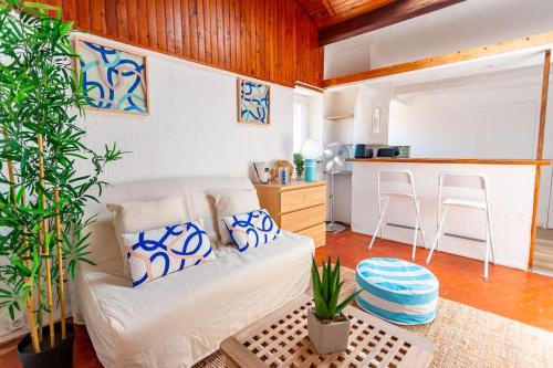 un salon avec un canapé blanc et une cuisine dans l'établissement Nid douillet avec vue incroyable, à Marseille