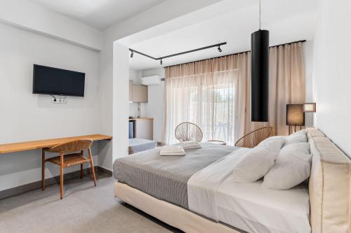 a bedroom with a bed and a desk and a television at blue symphony suites and apartments in Nikiana