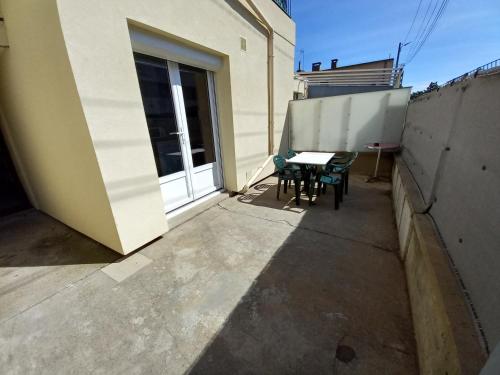 a patio with a table and chairs on a balcony at Appart T3 avec Cours et Parking Privé in Montélimar