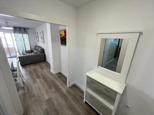 a living room with a mirror and a couch at Apartamentos Calypso Altamar in Alcossebre