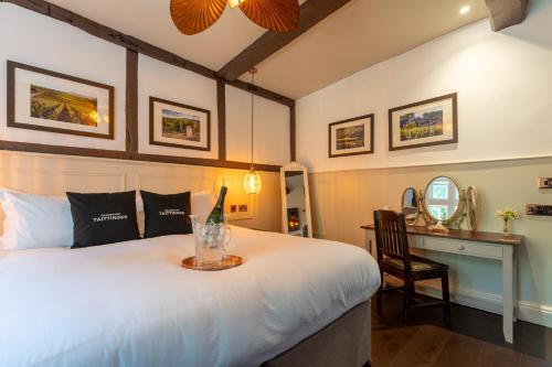 a bedroom with a bed with a desk and a chair at Woolpack Inn in Canterbury