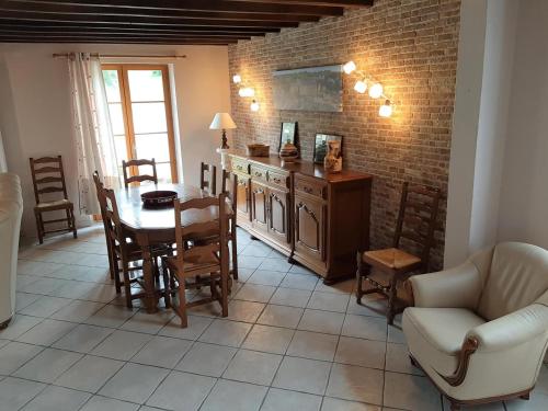 une cuisine et une salle à manger avec une table et des chaises dans l'établissement Le chant des oiseaux, à Givron