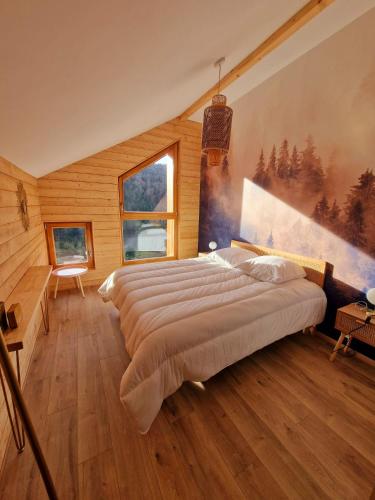 une chambre avec un grand lit avec un tableau au mur dans l'établissement Gîte du Mont d'Air 4 étoiles, au cœur du massif vosgien, bain nordique, à Ventron