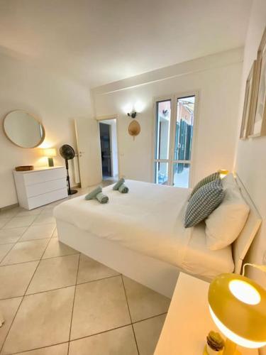 a bedroom with a large white bed and a mirror at Appartamento Giardino e Parcheggio in Borgio Verezzi